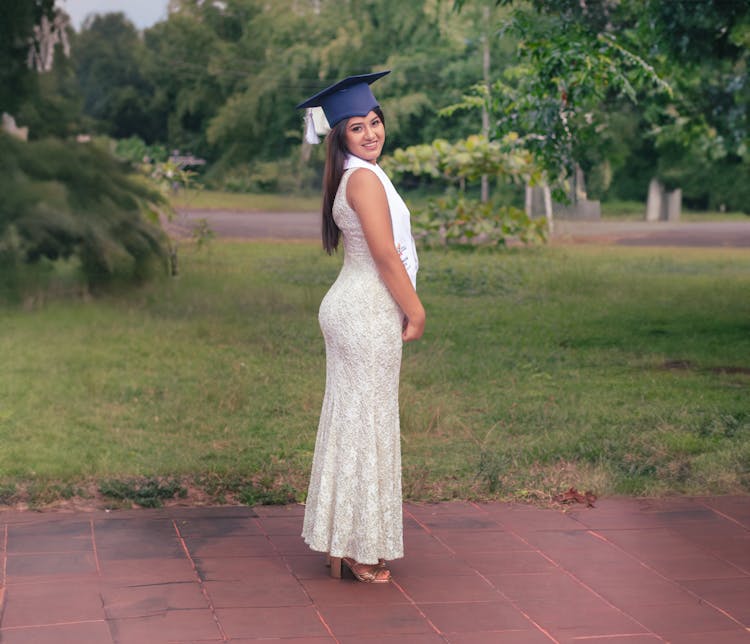 Smiling Graduate In White Dress And Academic Hat