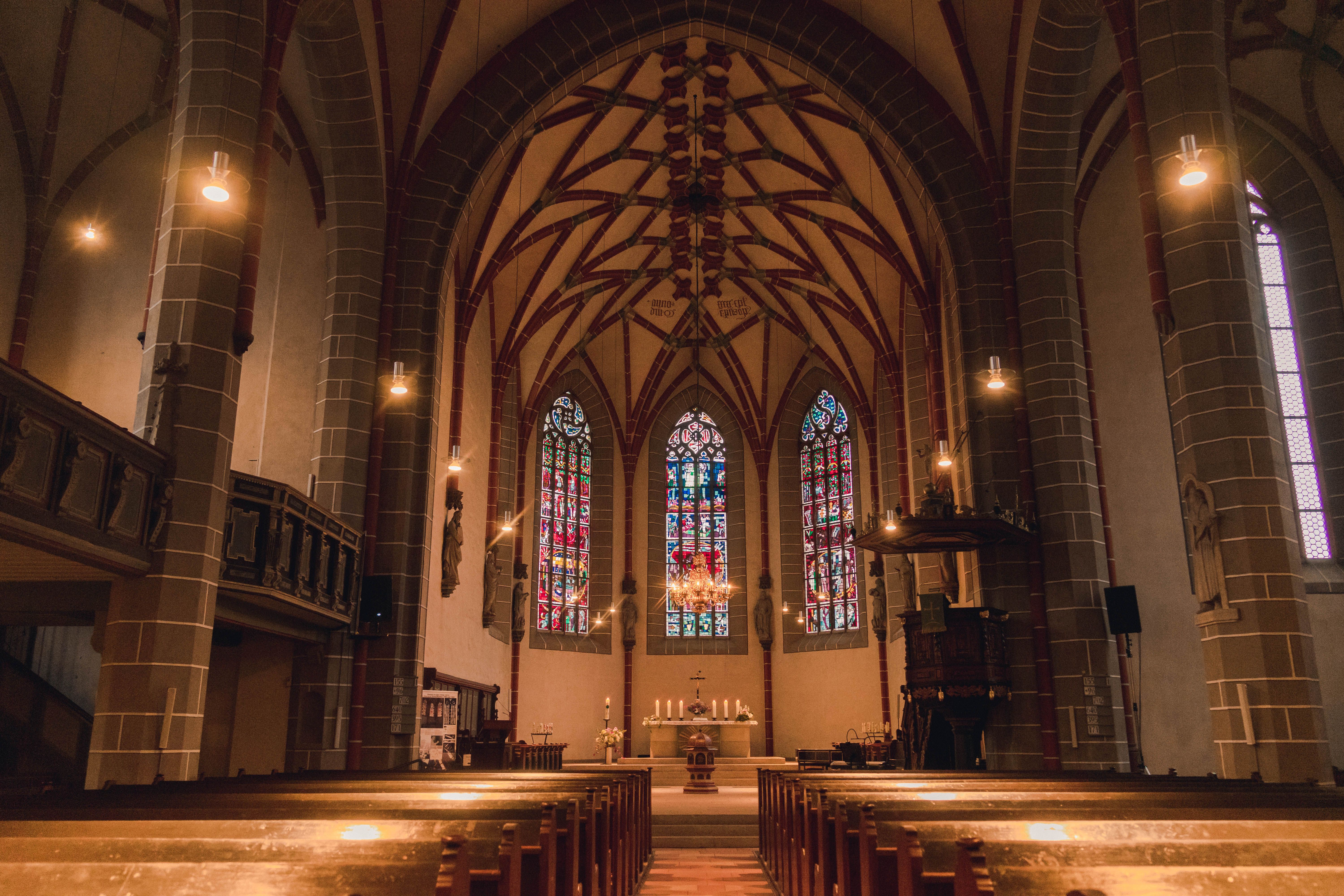 A beautiful Gothic church interior showcasing stained glass windows and vaulted ceiling.