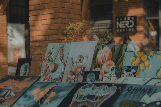 A lively display of colorful paintings in an outdoor urban art exhibition, capturing creativity.