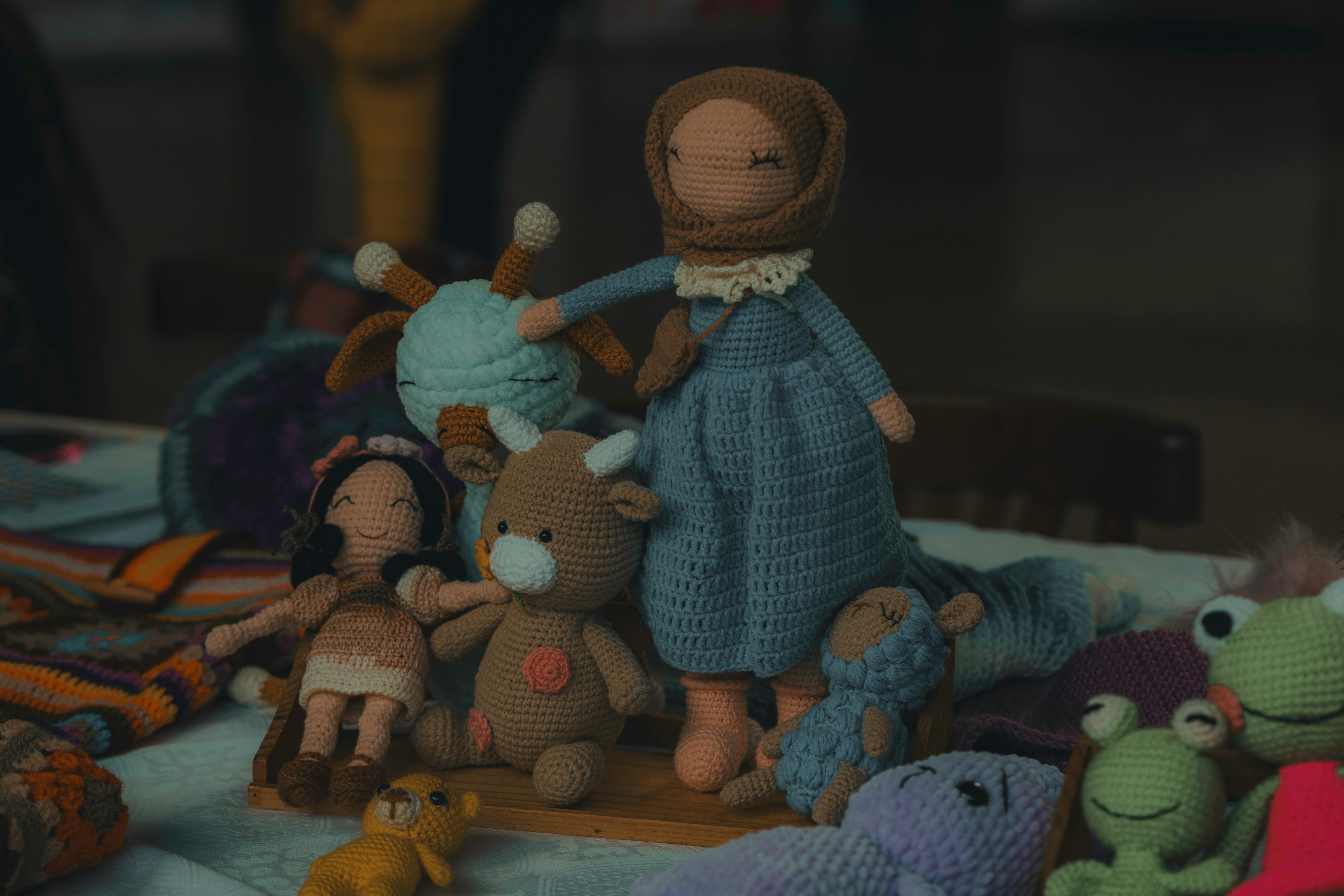 A collection of handmade knitted dolls and stuffed animals, perfect for children related to unique crochet patterns for sale