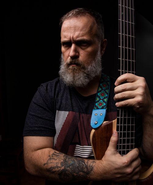 Free Serious bearded musician poses with electric guitar in a studio setting against a dark background. Stock Photo