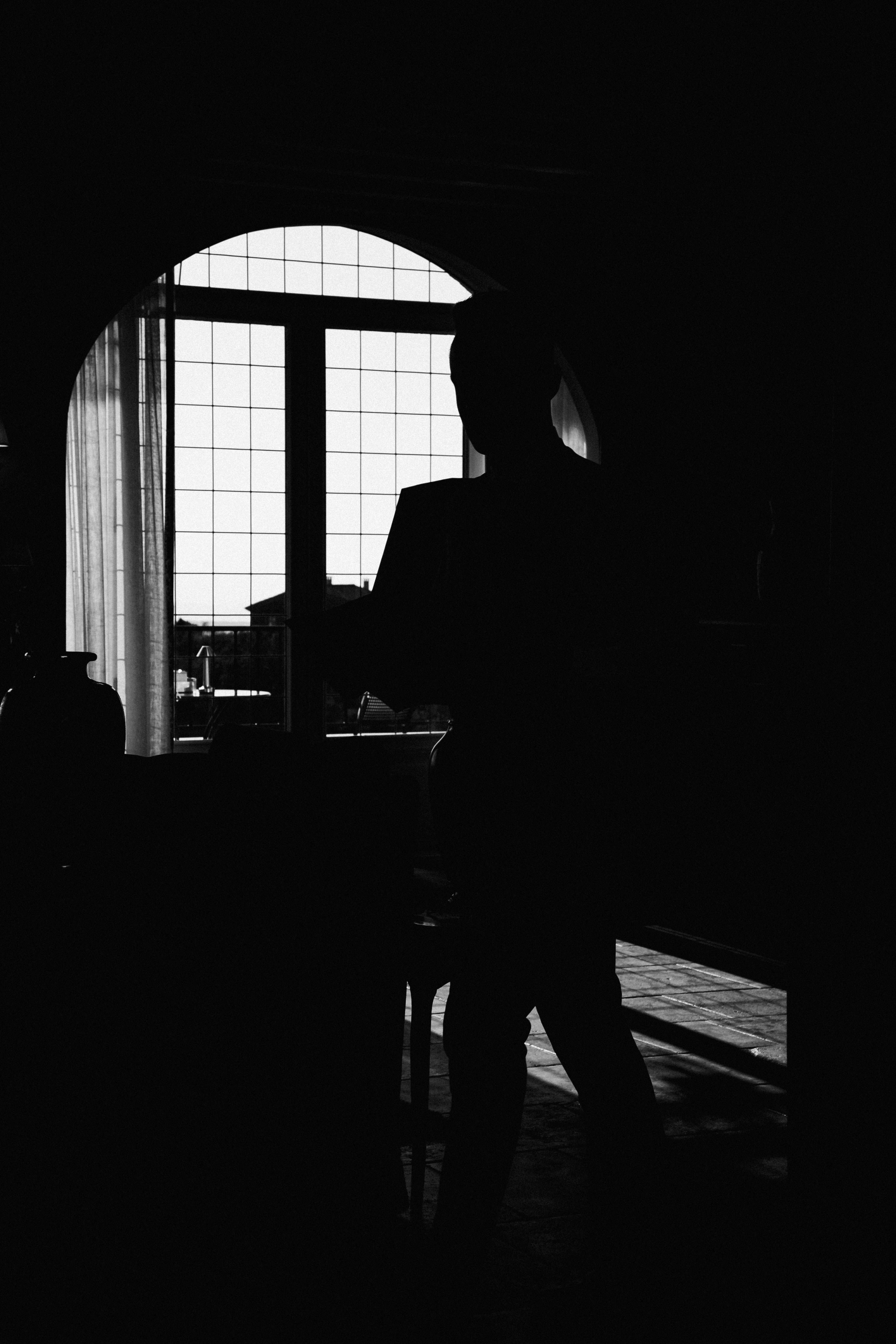 Silhouette of a Person in a Dark Room with a Window · Free Stock Photo