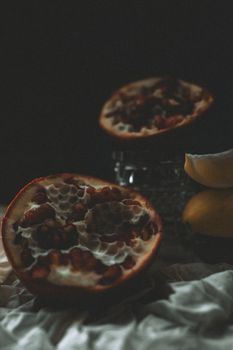 Dark and moody close-up of pomegranate halves showcasing texture and freshness.