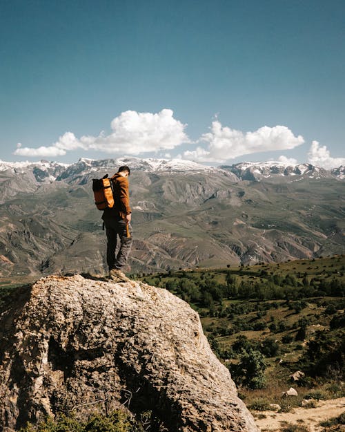 adam, aşınmış kaya, dağlar içeren Ücretsiz stok fotoğraf