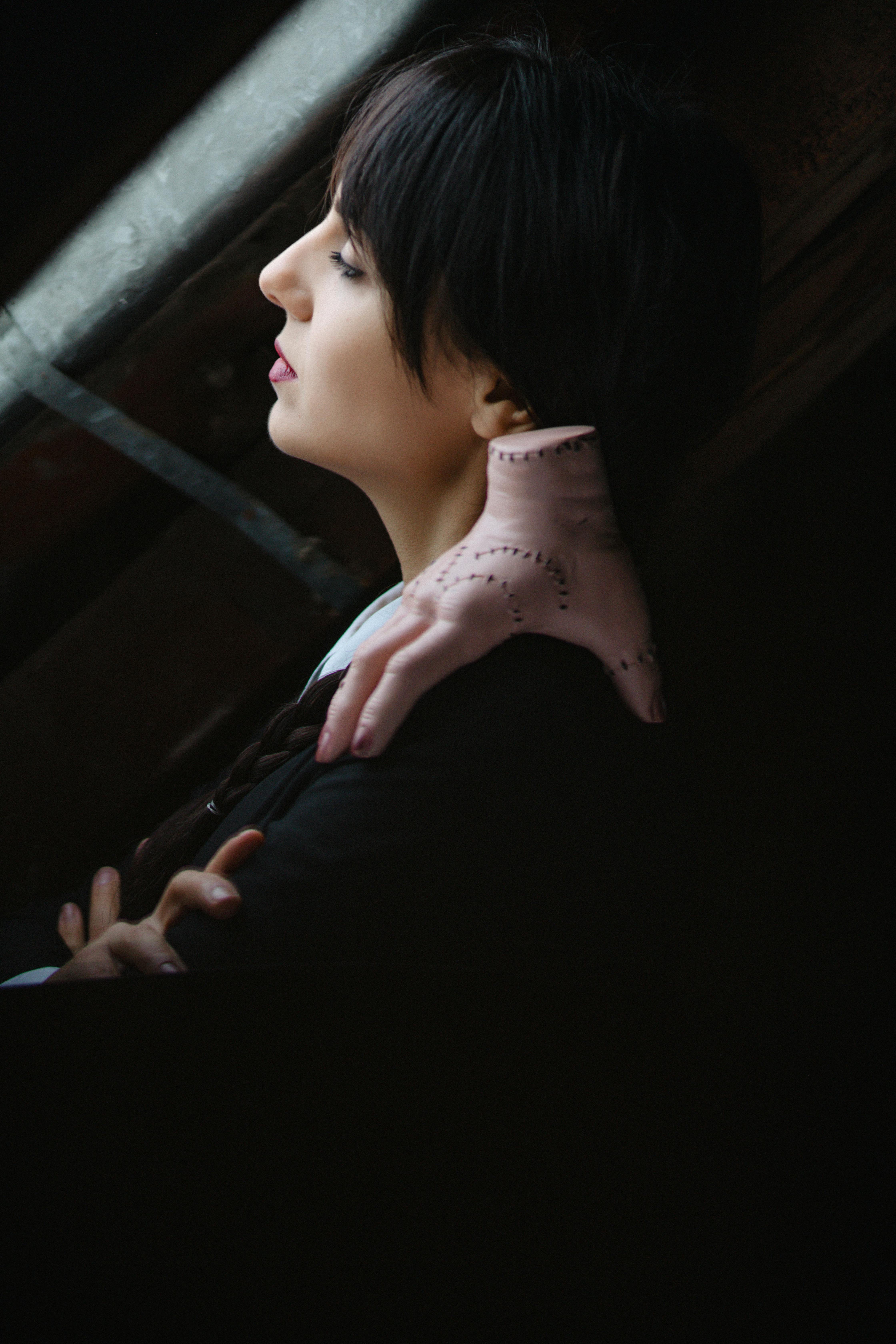 A moody portrait of a girl in costume with a hand accessory, inspired by a fictional character.
