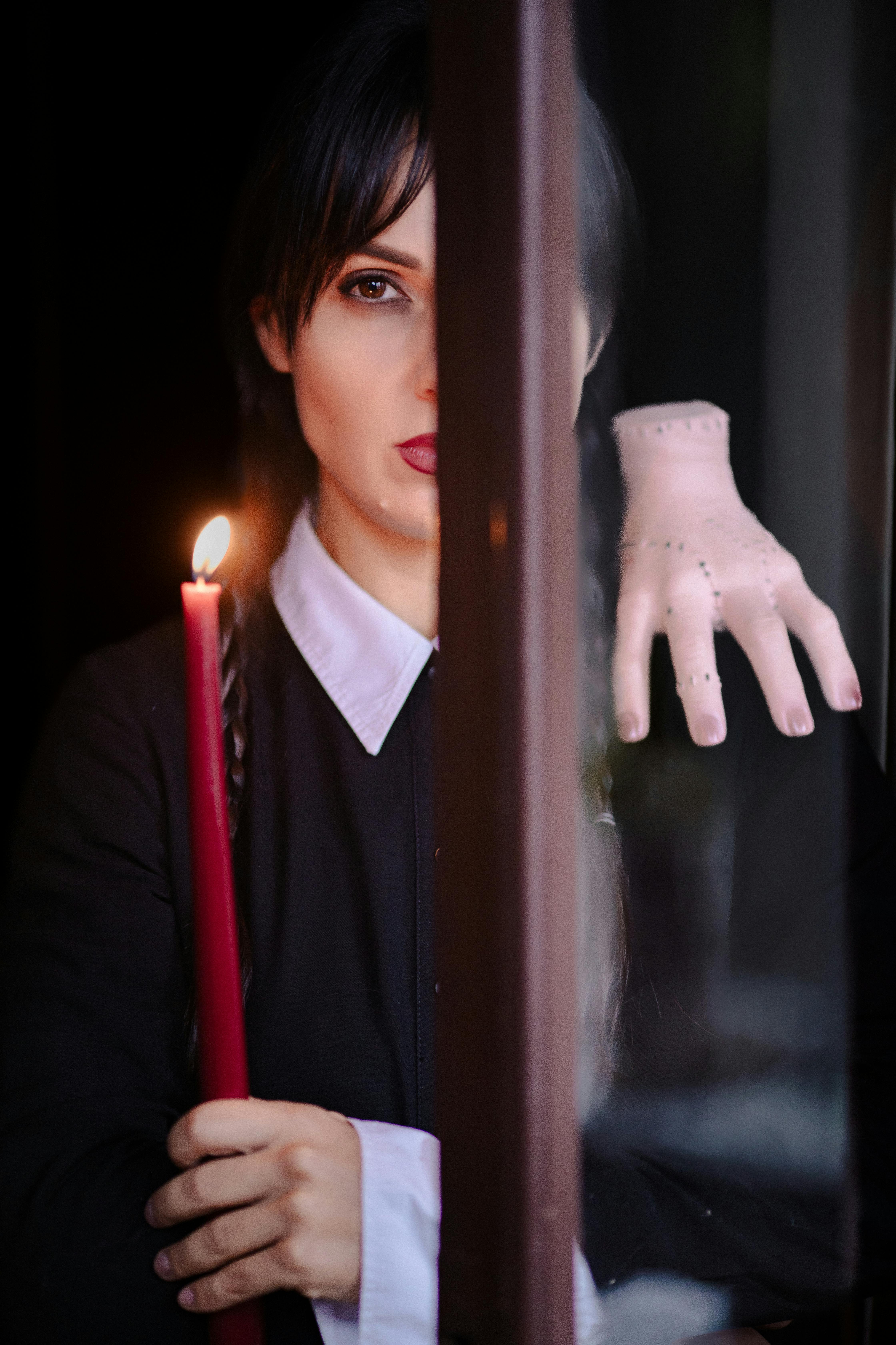 woman in wednesday addams costume with thing