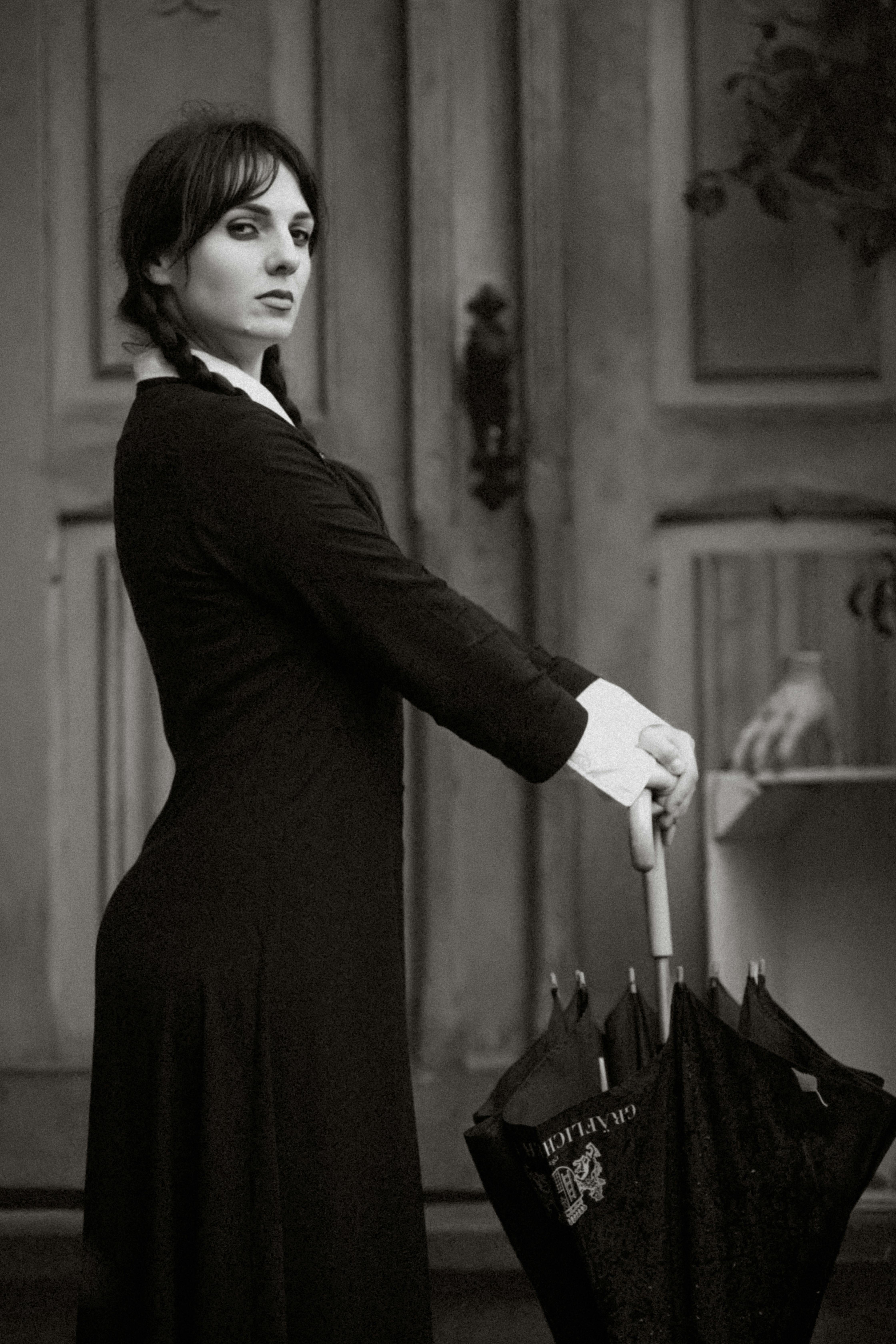 woman in wednesday addams costume with umbrella