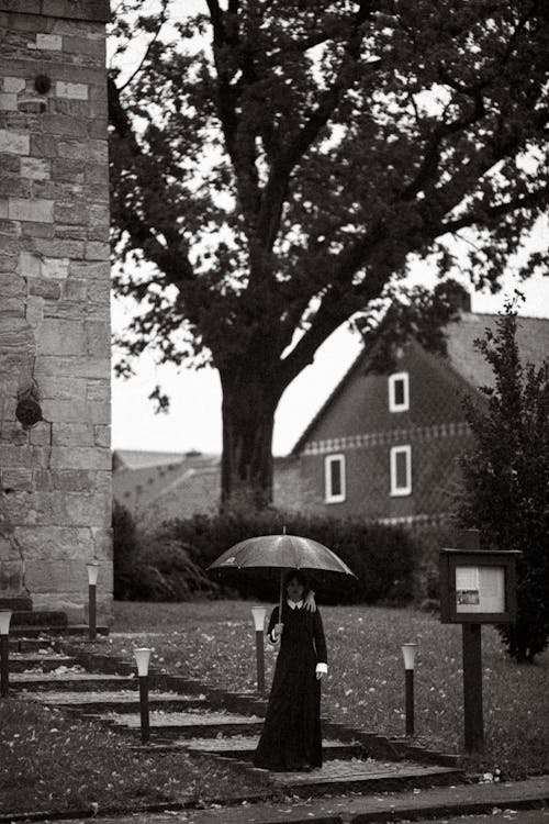Creepy Wednesday Addams with Thing on Shoulder under Umbrella