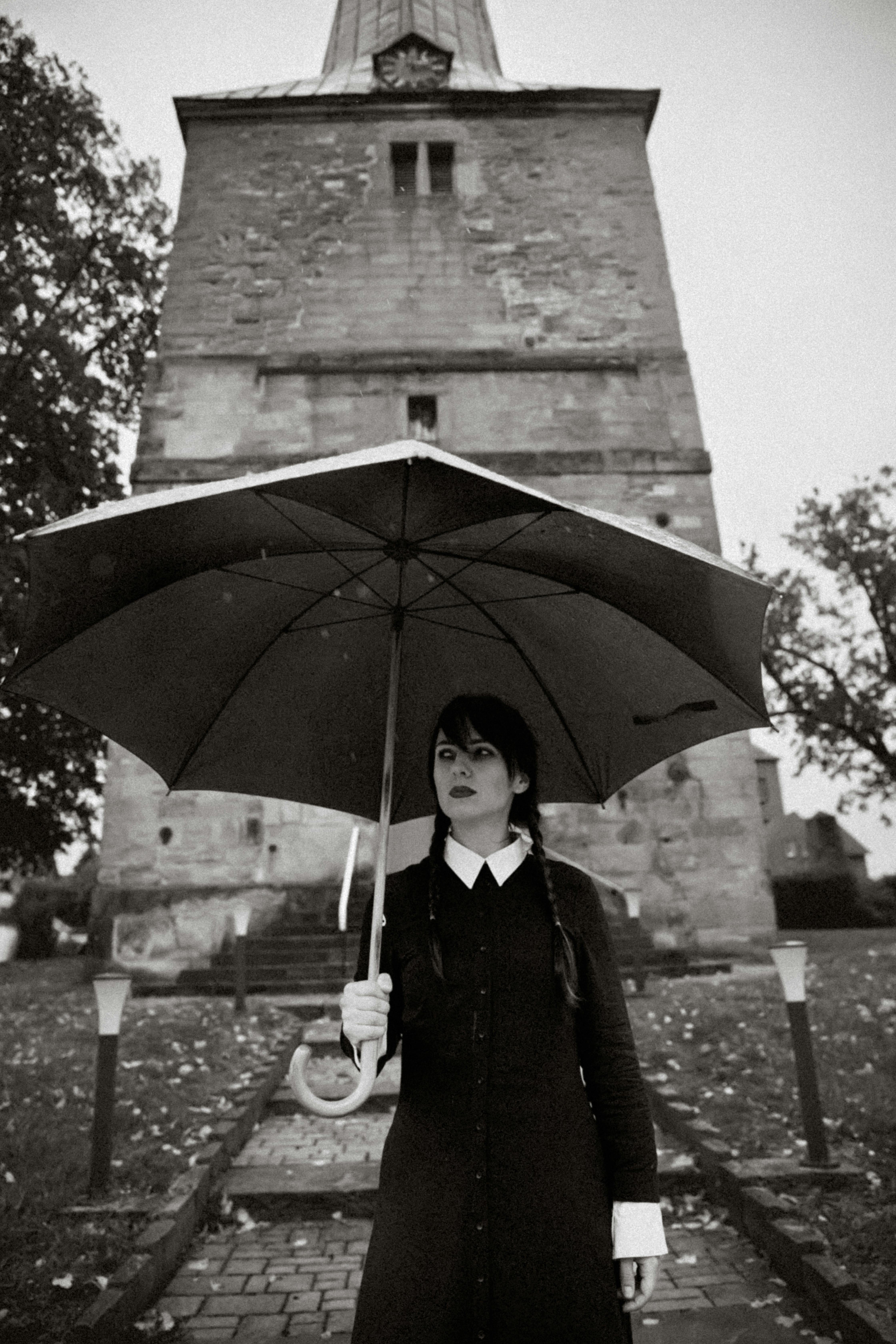 wednesday addams style woman under umbrella