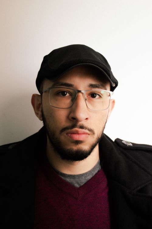 Free Portrait of a man wearing a cap and eyeglasses in a studio setting. Stock Photo