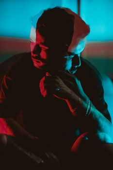 Artistic double exposure portrait with dramatic red and blue lighting.
