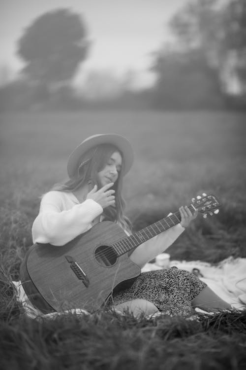 Woman Holding a Guitar in a Field in Black and White 