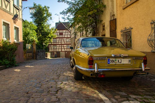 Back of a Green Classic Daimler Sovereign Parked on a Cobblestone Street