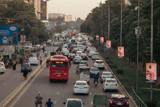 A bustling urban scene with heavy traffic on an arterial road in Lahore, Punjab, Pakistan.