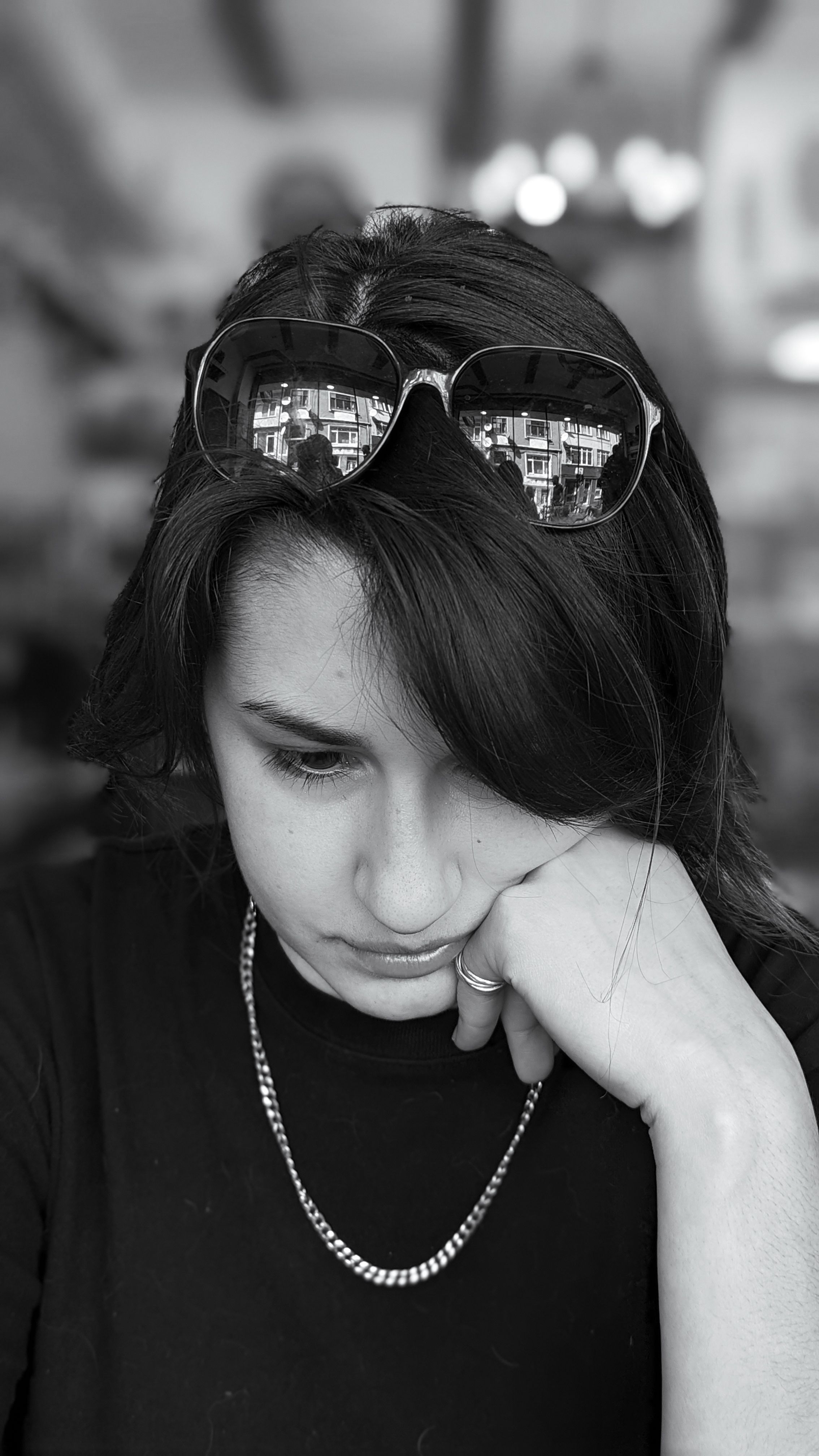 Thoughtful woman wearing sunglasses indoors in Beyoğlu, İstanbul.