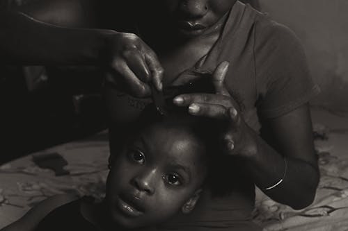 Mother Combing her Small Daughter Hair