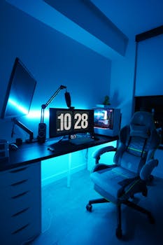 A well-lit gaming workstation featuring dual monitors and a comfortable gaming chair, perfect for gamers.