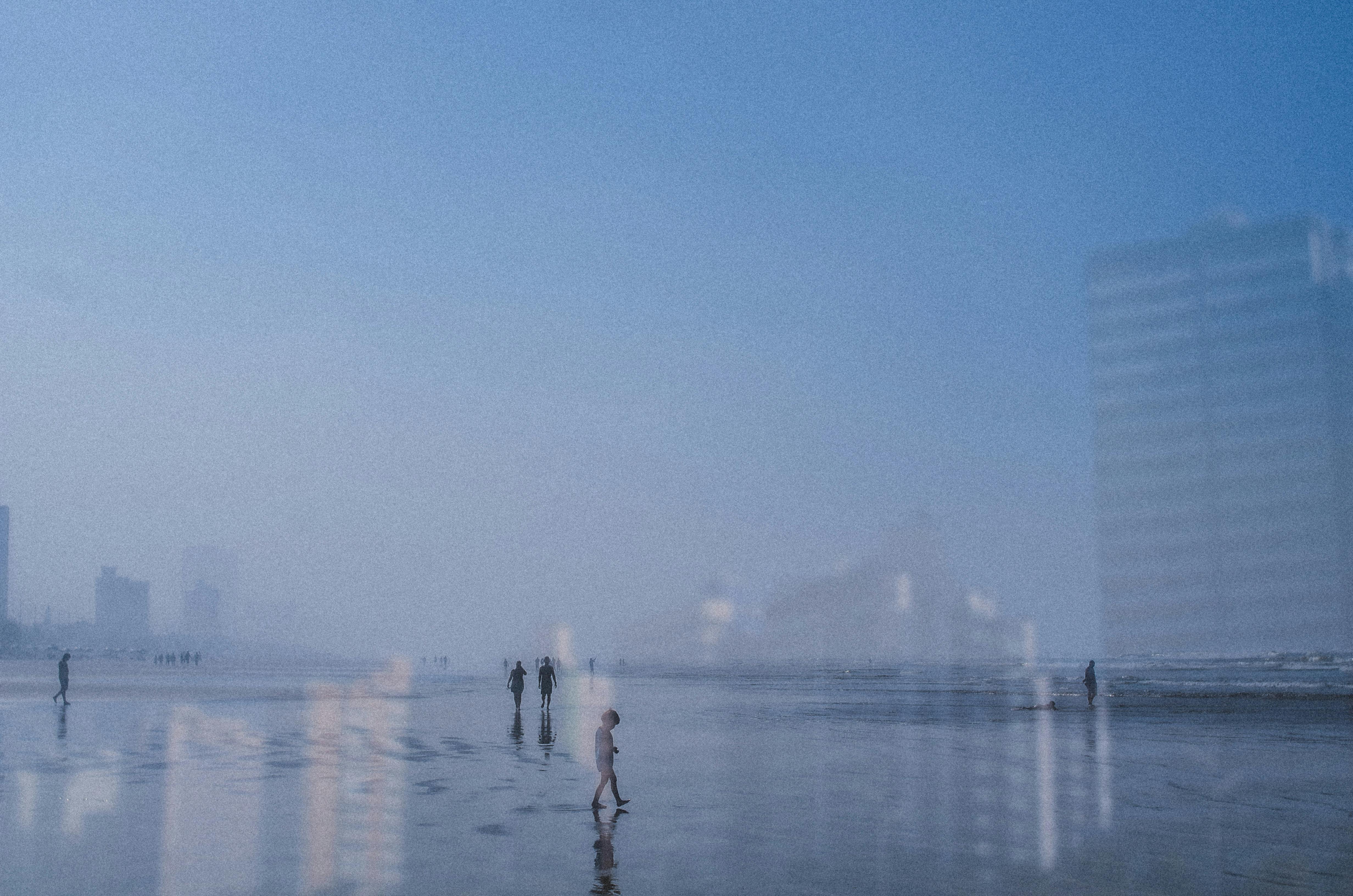 Serene beach scene in São Paulo with skyscrapers and foggy ambiance.