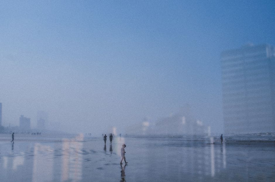 Serene beach scene in São Paulo with skyscrapers and foggy ambiance.