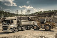 Front Load Loader Beside White Dump Truck