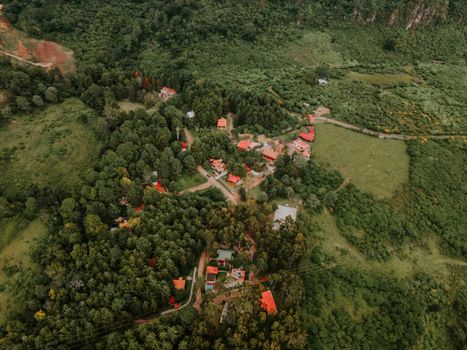 A picturesque aerial view of a countryside with red rooftops surrounded by lush greenery and trees.