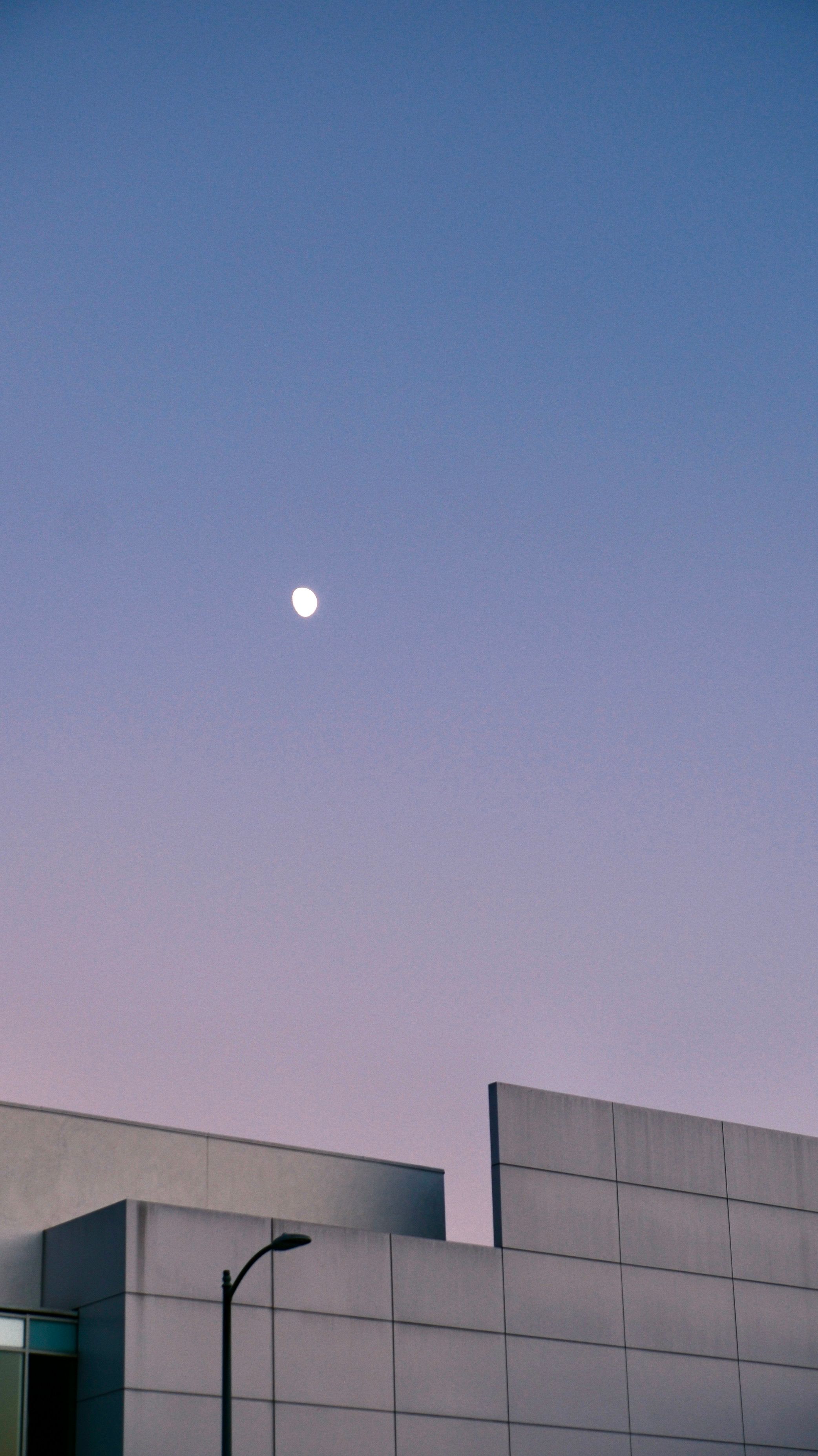 Minimalist modern architecture against a twilight sky with moon.