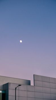 Minimalist modern architecture against a twilight sky with moon.