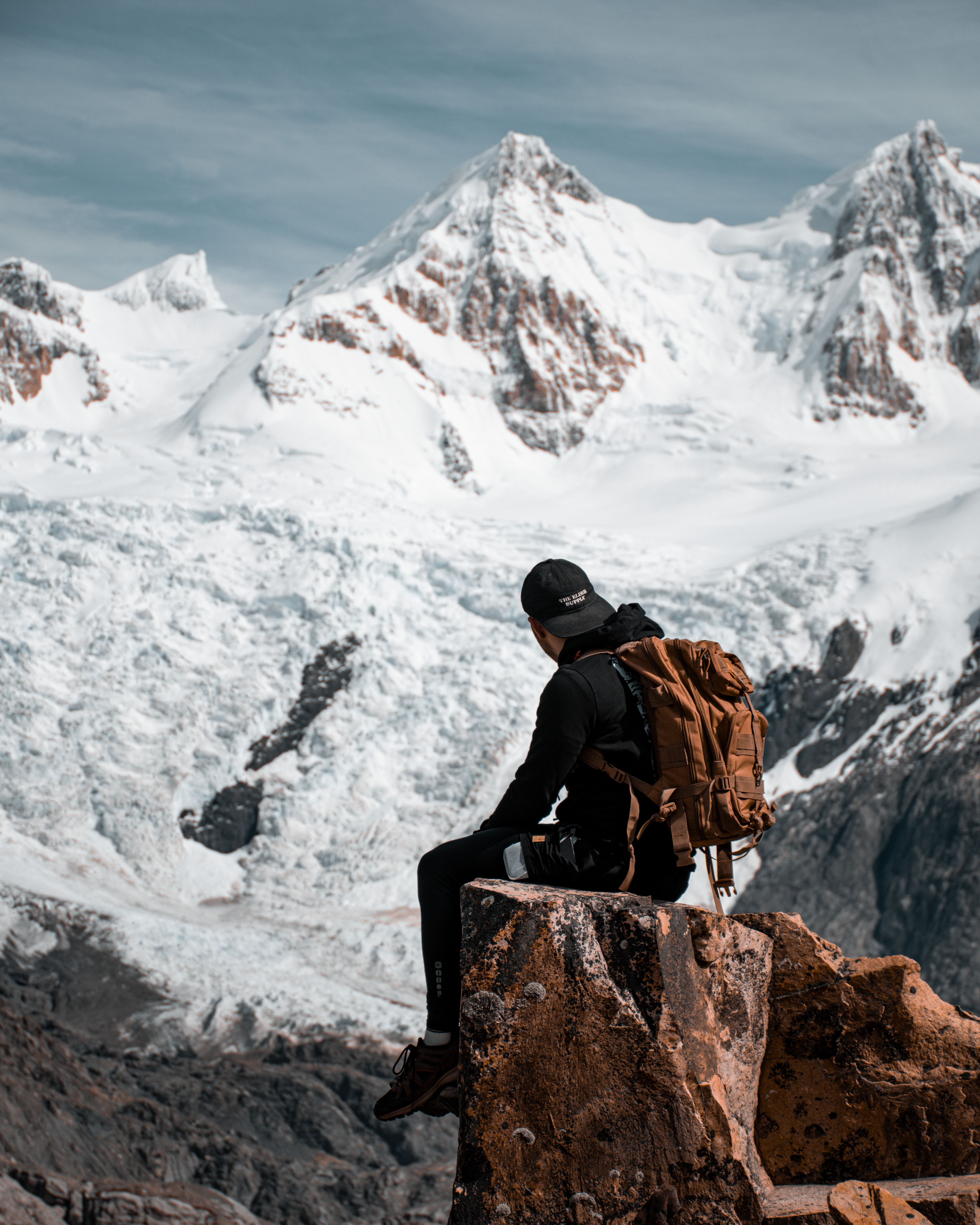Hiker enjoys breathtaking view of snow-covered mountains in El Chalten, Argentina.