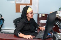Young Woman Wearing a Hijab Working at a Computer Desk