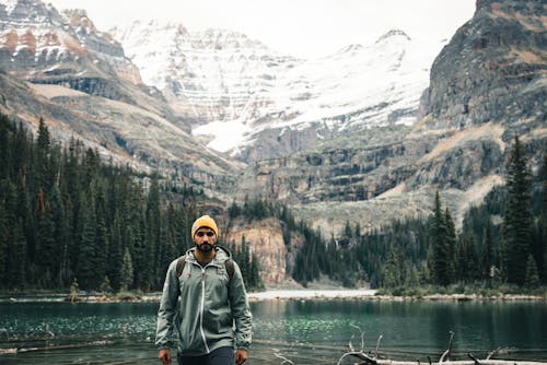Hiker in Yellow Beanie Hat by Lake in Mountains