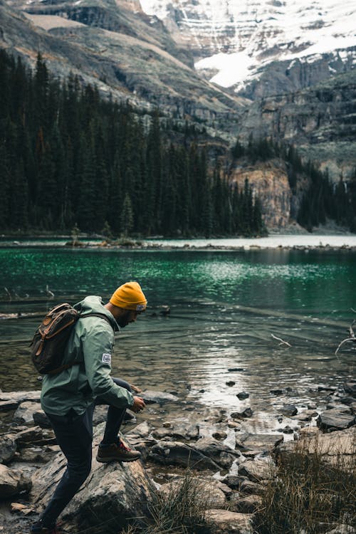 Man Hiking on Lakeshore in Mountains