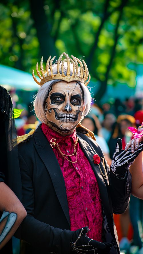 Free Colorful portrait of a man in traditional Day of the Dead attire with face paint and crown. Stock Photo