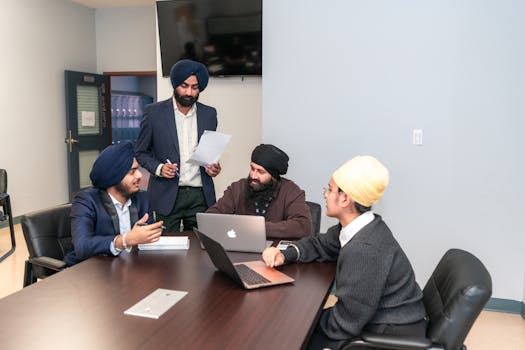 A diverse group of professionals engaged in a collaborative meeting in an office setting.
