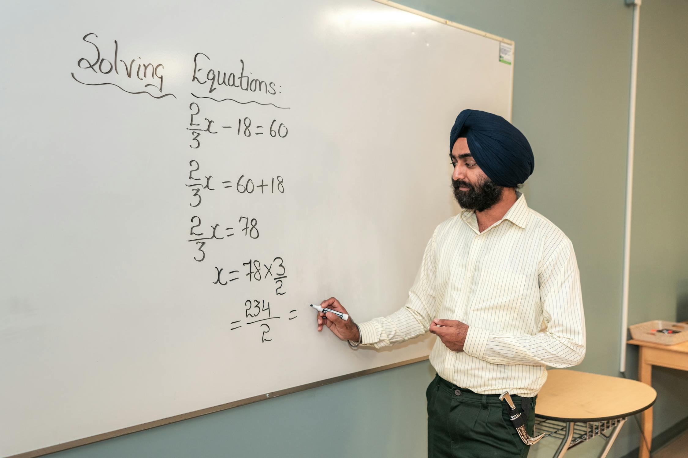 Teacher Solving a Mathematical Formula on a Whiteboard · Free Stock Photo