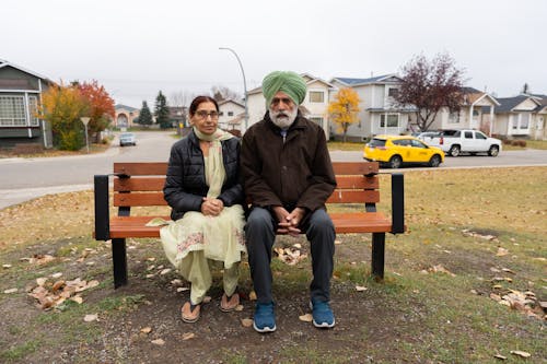 Couple Sitting on Bench in Urban Suburb