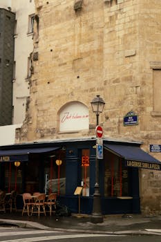 Rustic bistro with blue awning at Parisian street corner, capturing urban charm.