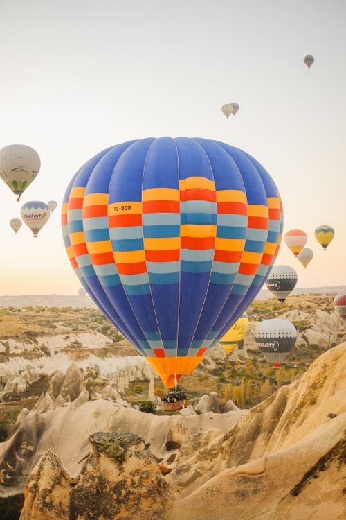 Free Colorful hot air balloons soar above the unique rock formations of Cappadocia, Turkey. Stock Photo
