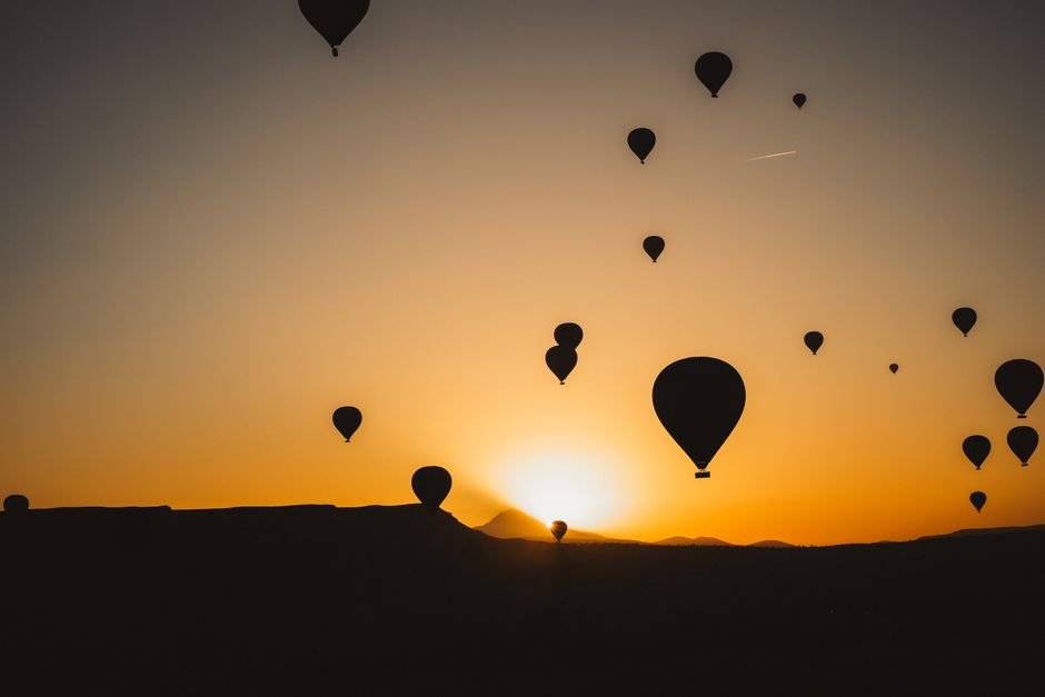 Hot air balloons floating over the ancient temples of Luxor, Egypt at sunrise