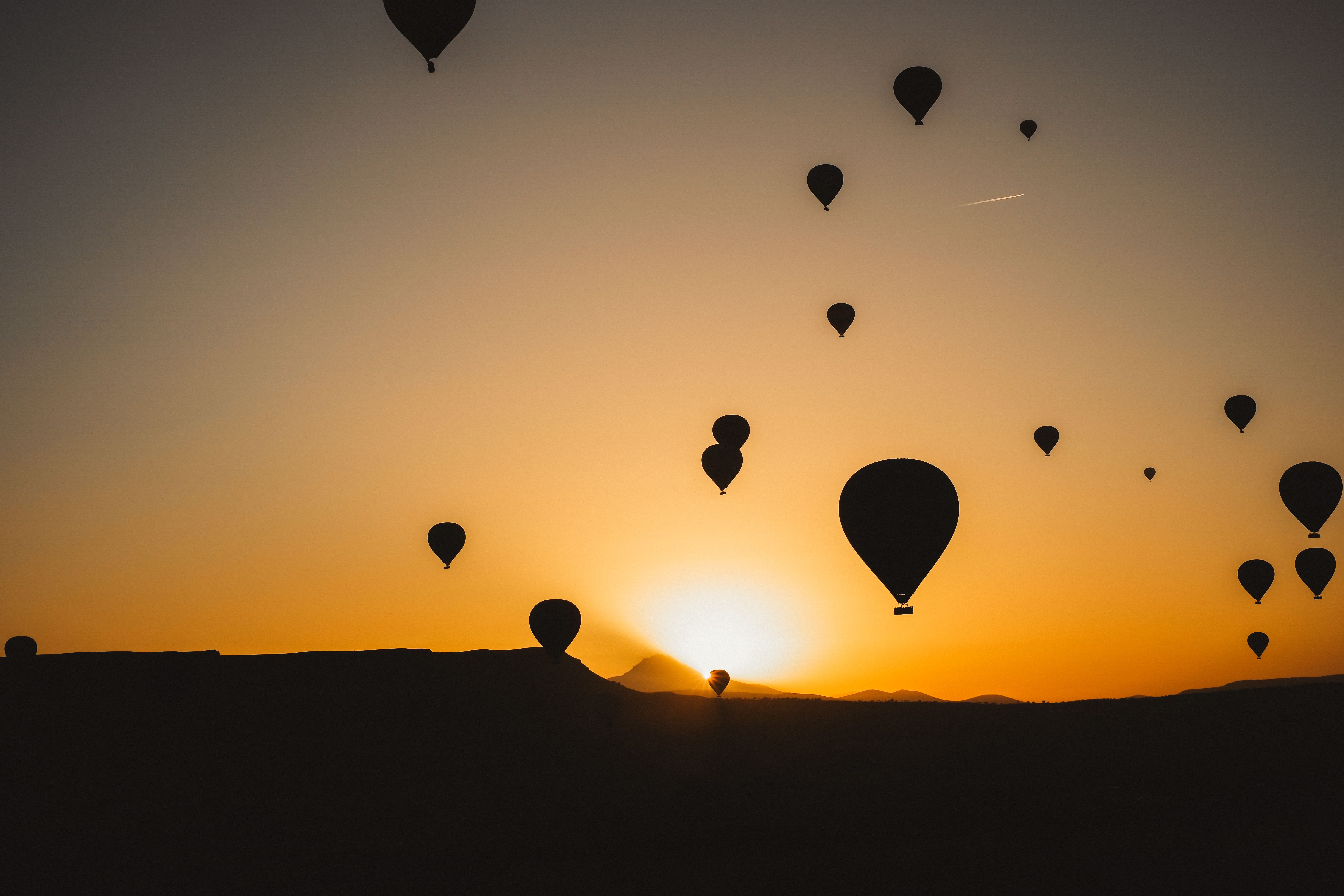 Silhouettes of Hot Air Balloons Flying against the Sky at Sunset · Free ...