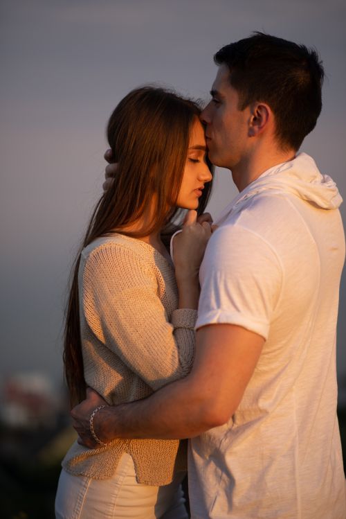 Free Tender moment of a couple embracing outdoors during sunset, capturing love and connection. Stock Photo