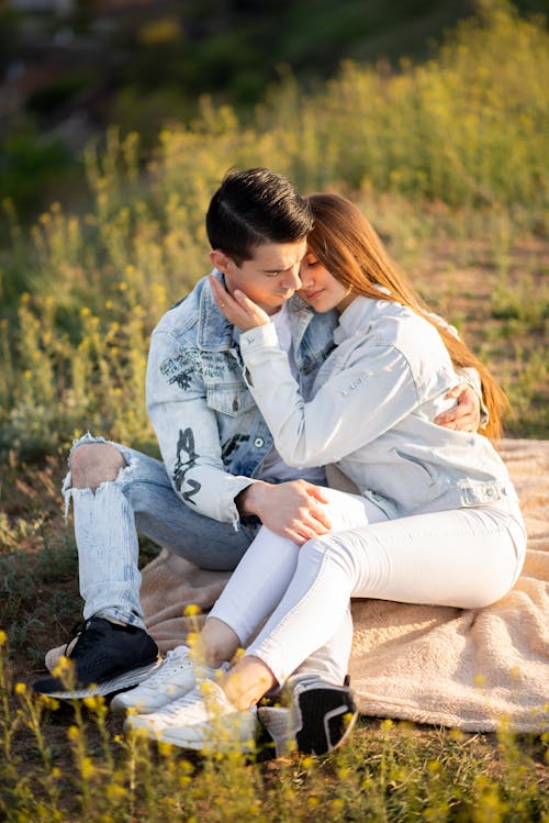 Couple Sitting and Hugging on Meadow