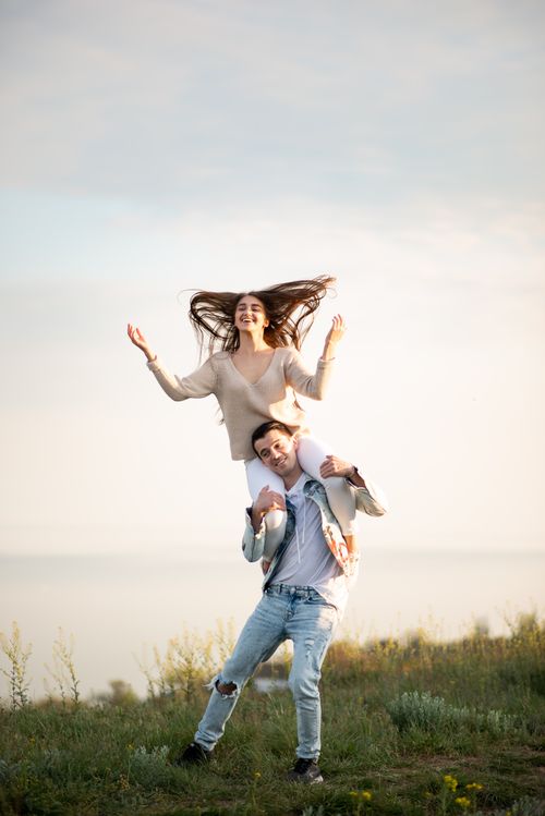 Free A happy couple enjoying a day outdoors in a rural grassland setting, showcasing joy and connection. Stock Photo