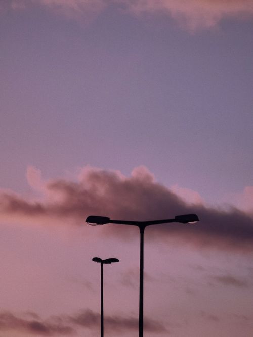 Free Two street lamps silhouetted against a vibrant evening sky in Munich, Germany. Stock Photo