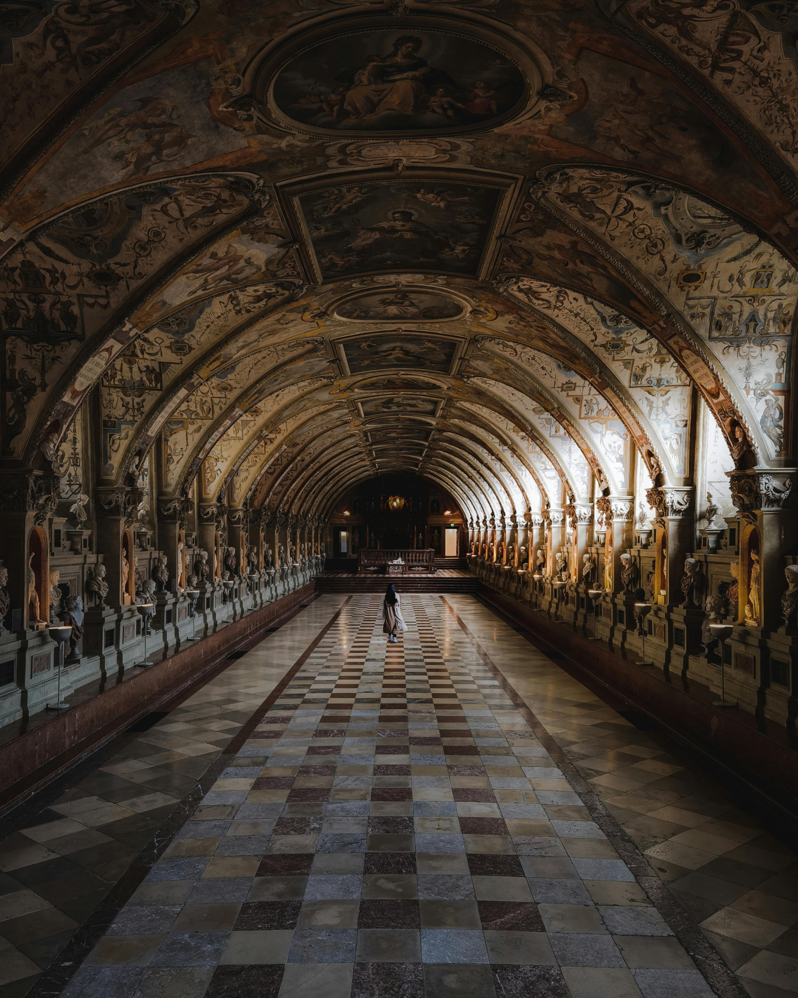 A majestic corridor adorned with sculptures and frescoes at the Munich Residence.