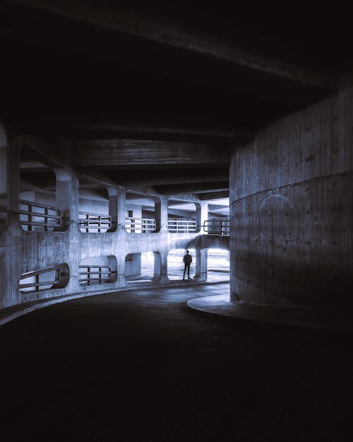 Silhouette of a Man Standing at the End of a Dark Tunnel 