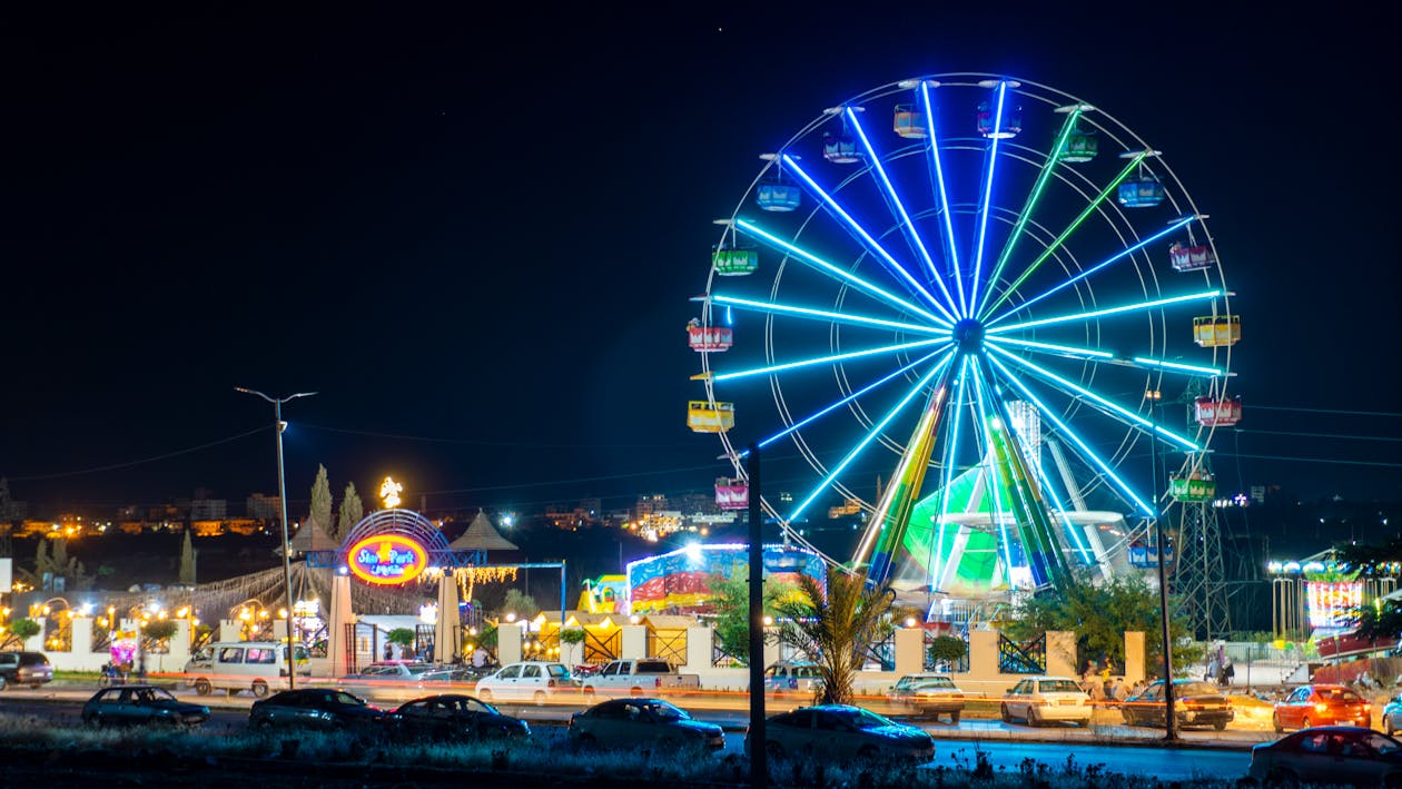 Illuminated Amusement Park with a Ferris Wheel at Night