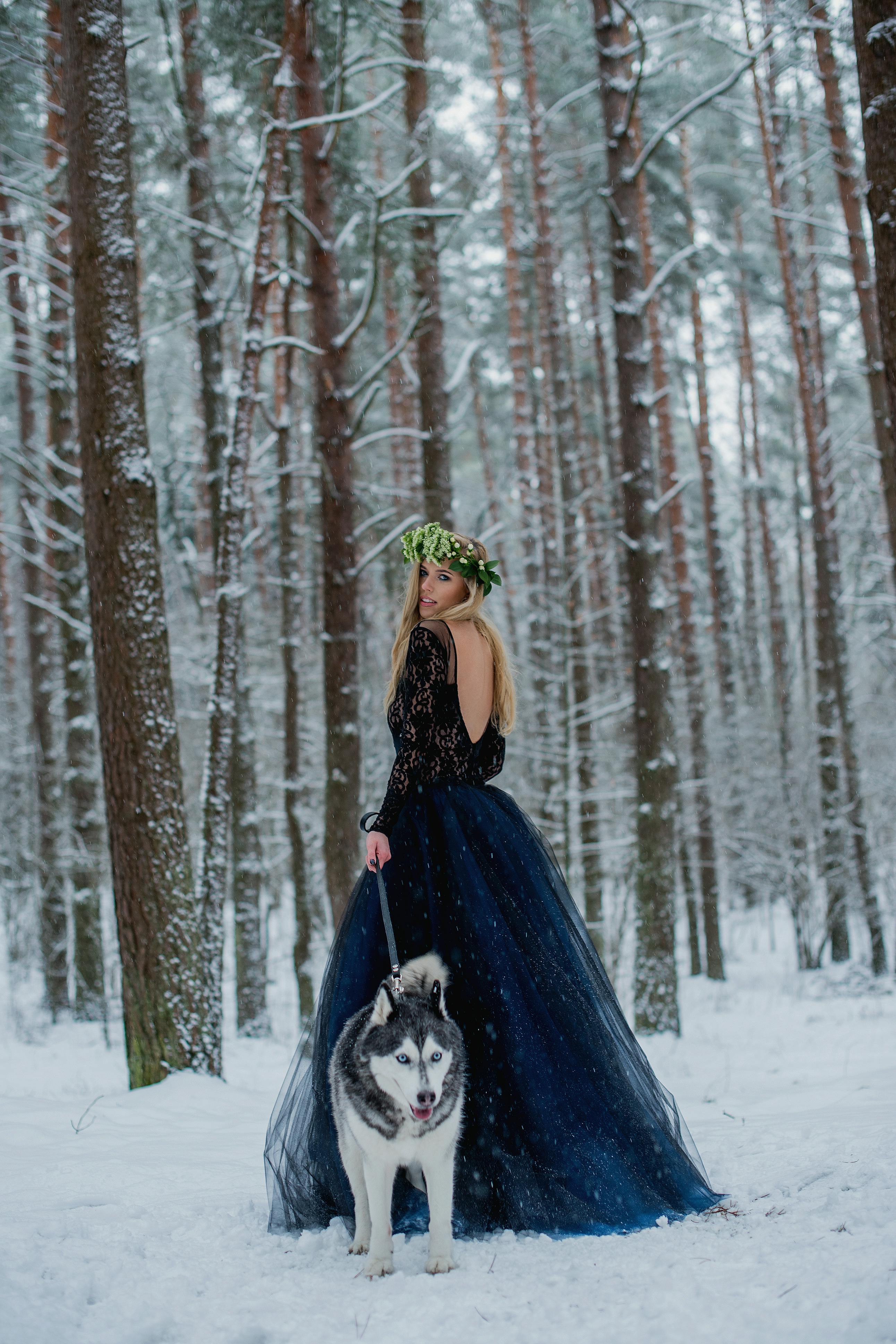 pretty girl with husky in forest at winter