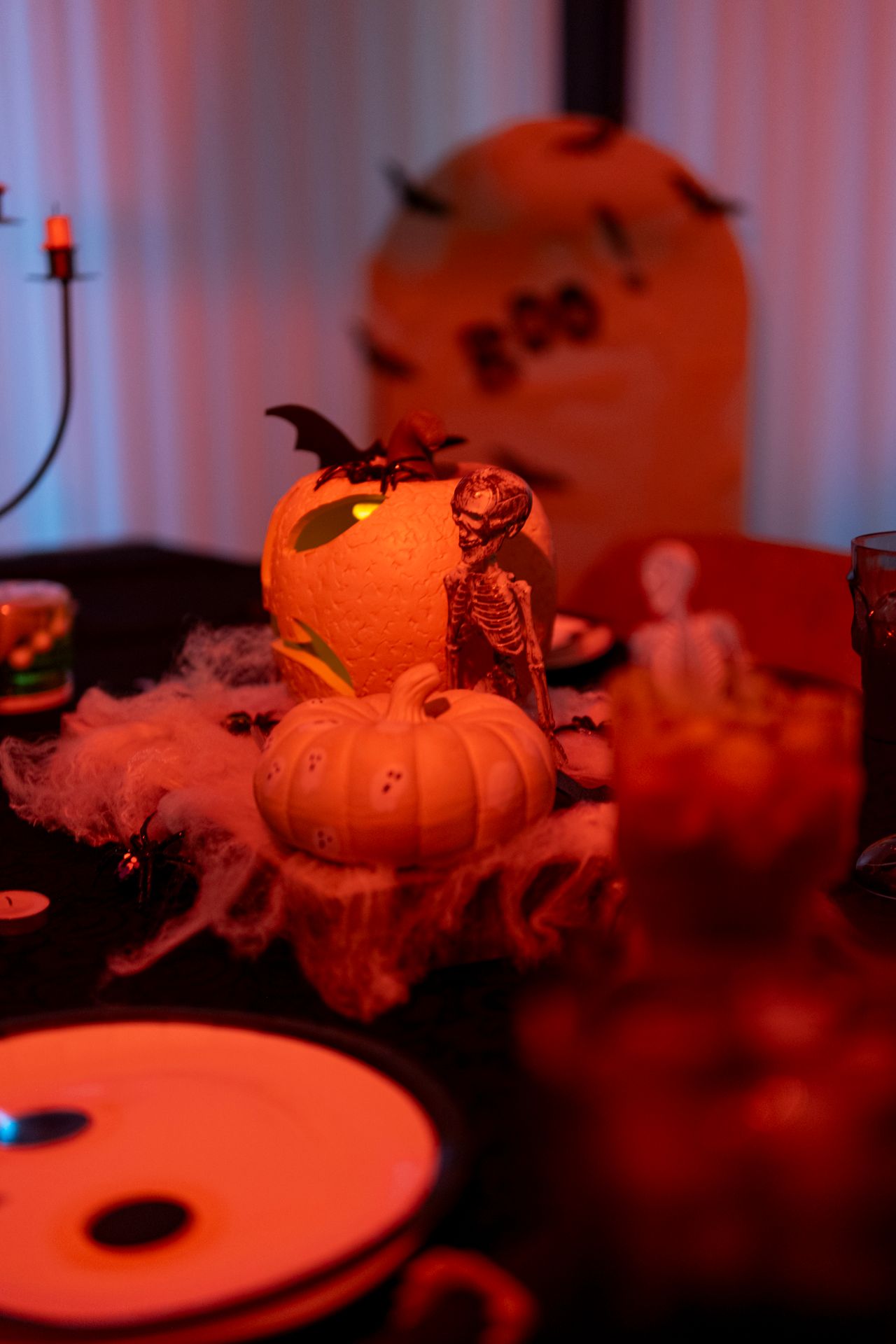 Spooky Halloween table with skeletons, pumpkins, cobwebs, and a glowing BOO sign