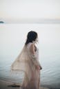 捕捉到一个穿着飘逸连衣裙的女人凝视着宁静的大海的宁静时刻