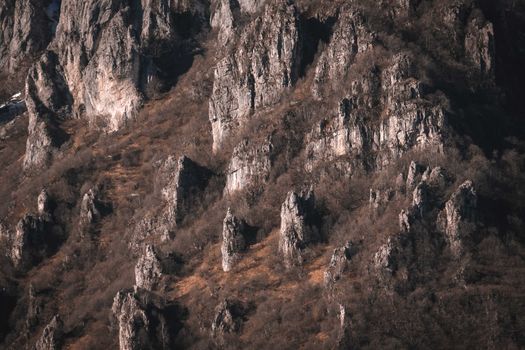 A captivating view of rugged autumn mountain rock formations with sparse vegetation.